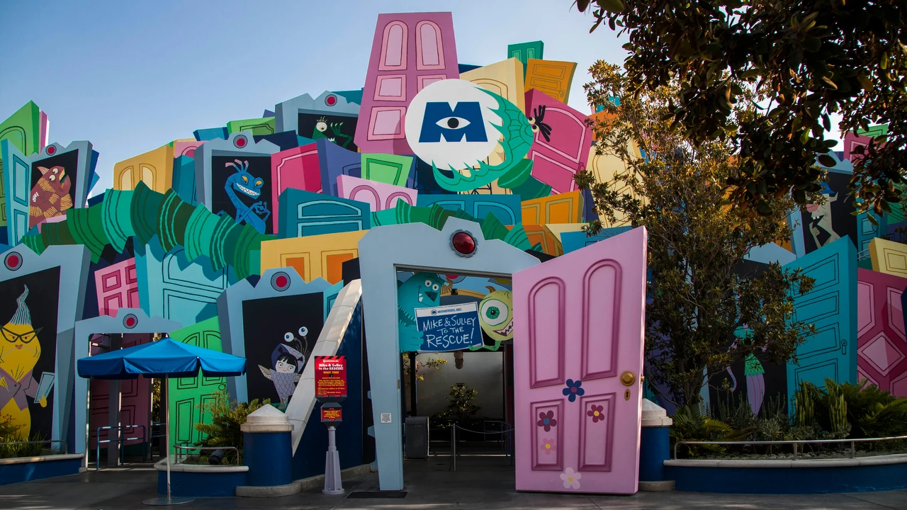Une façade colorée et caricaturale représentant des éléments de construction surdimensionnés comme des fenêtres et des portes, conçue de manière créative comme l'entrée de l'attraction Monsters Inc : Mike & Sulley to the Rescue!".