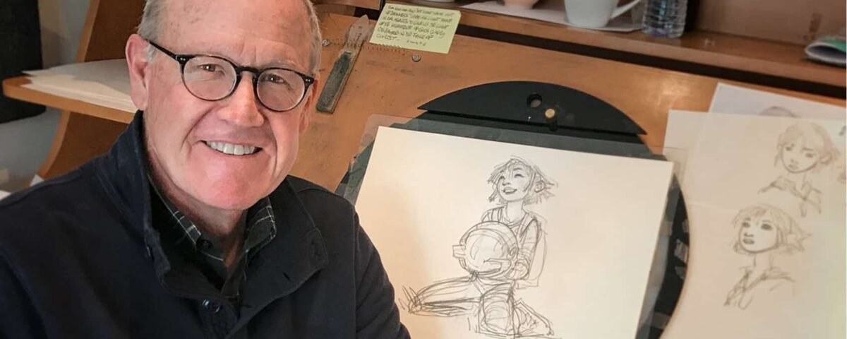 Un homme âgé portant des lunettes et une chemise noire sourit à la caméra, assis à un bureau avec des croquis de Glen Keane représentant une jeune femme exposés devant lui.