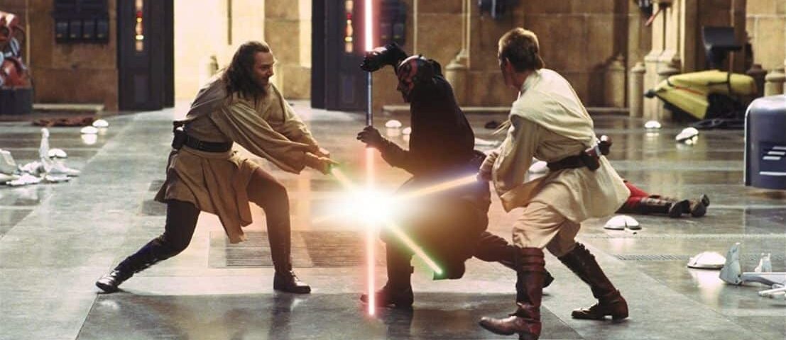 Deux Jedi, l'un avec un sabre laser bleu et l'autre avec un sabre laser vert, affrontent un Seigneur Sith brandissant un sabre laser rouge à double lame dans un grand couloir de "La Menace Fantôme".