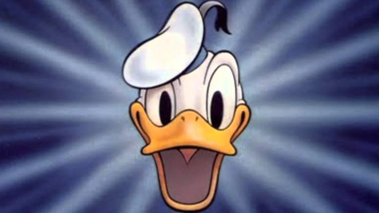 Une illustration de Donald Duck avec une expression choquée grande ouverte, sur un fond rayonnant bleu dynamique. Il porte son chapeau de marin classique avec un pompon noir.