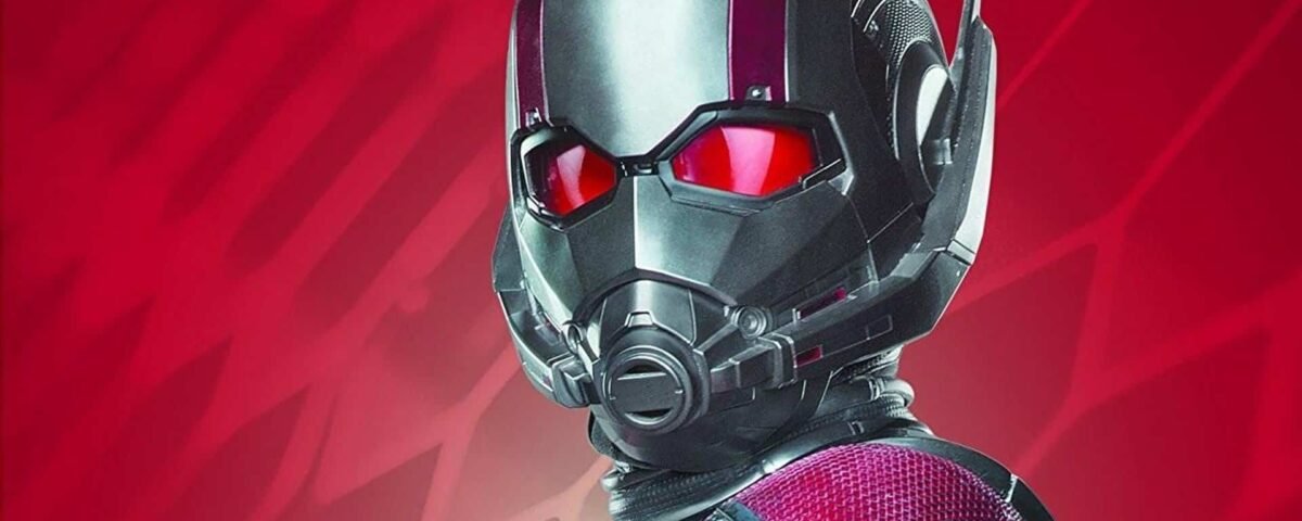 Gros plan du casque d'Ant-Man avec des yeux rouges brillants sur fond rouge, mettant en valeur les textures détaillées de sa combinaison et de son casque.