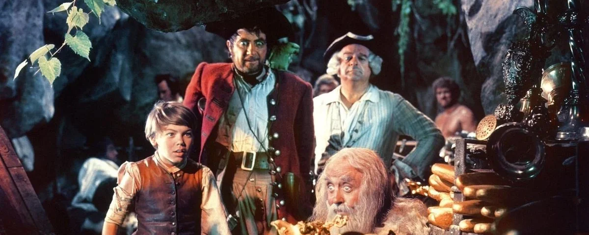 Un groupe d'aventuriers, dont un jeune garçon, un homme robuste et un homme plus âgé, examinent un trésor sur "l'Île au Trésor" dans une grotte remplie de pièces d'or.