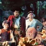 Un groupe d'aventuriers, dont un jeune garçon, un homme robuste et un homme plus âgé, examinent un trésor sur "l'Île au Trésor" dans une grotte remplie de pièces d'or.