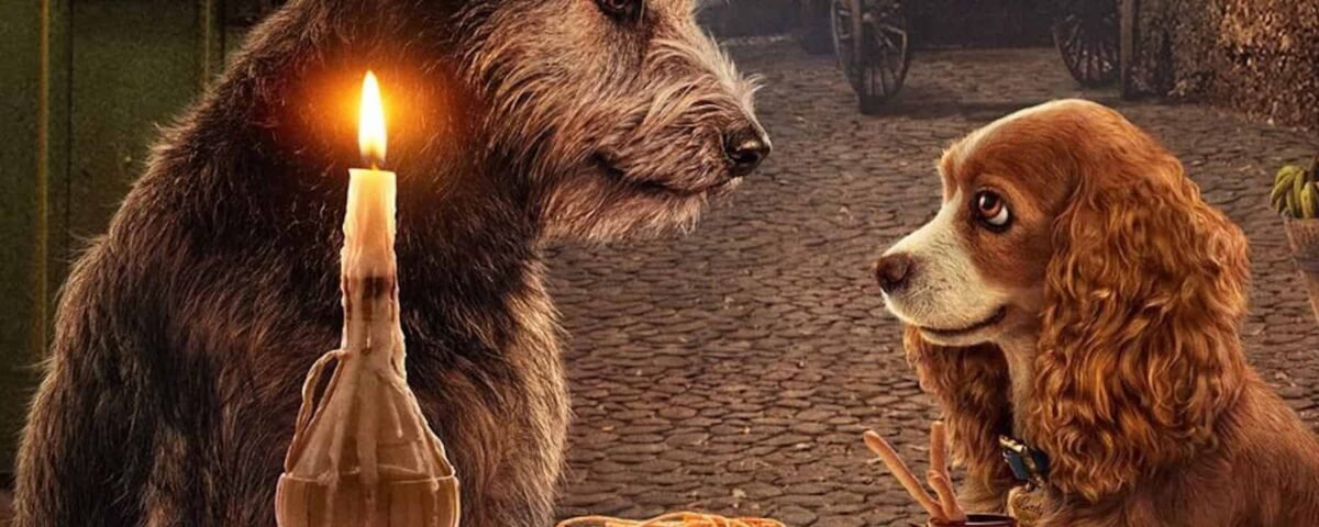 Deux chiens, un grand débraillé et un plus petit bronzé, assis à une table avec une assiette de spaghetti et une bougie allumée, partageant un dîner romantique rappelant "La Belle et