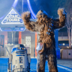 Personnages Chewbacca et R2-D2 à l'attraction Star Tours, avec Chewbacca posant les bras levés et R2-D2 à côté de lui.