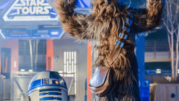 Personnages Chewbacca et R2-D2 à l'attraction Star Tours, avec Chewbacca posant les bras levés et R2-D2 à côté de lui.