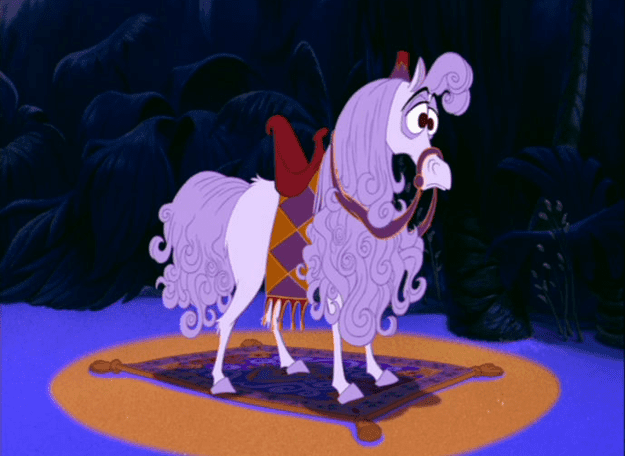 Un cheval Disney animé avec d'épaisses boucles blanches et une expression surprise, debout sur un tapis orange à motifs dans un décor de forêt sombre. Le cheval est orné d'une selle rouge et d'un harnais doré.