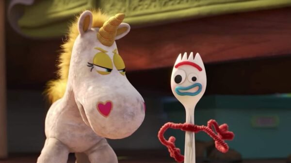 Personnages animés de Toy Story, dont une peluche licorne avec une corne dorée et un nez en forme de cœur, et Forky, une cuillère avec des yeux écarquillés et des bras de cure-pipe rouges, dans un enfant