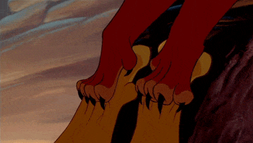 Scène d'animation du film "Le Roi Lion" montrant en gros plan les pieds griffus d'un personnage agrippé au bord d'une falaise, sur fond de vaste terrain rocheux.