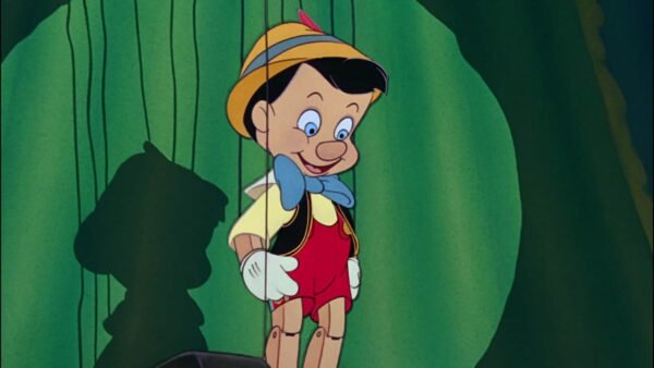 Pinocchio, un garçon marionnette en bois avec un nœud papillon bleu et un chapeau jaune, se tient dans une forêt, souriant, avec son ombre projetée sur un rocher derrière lui.