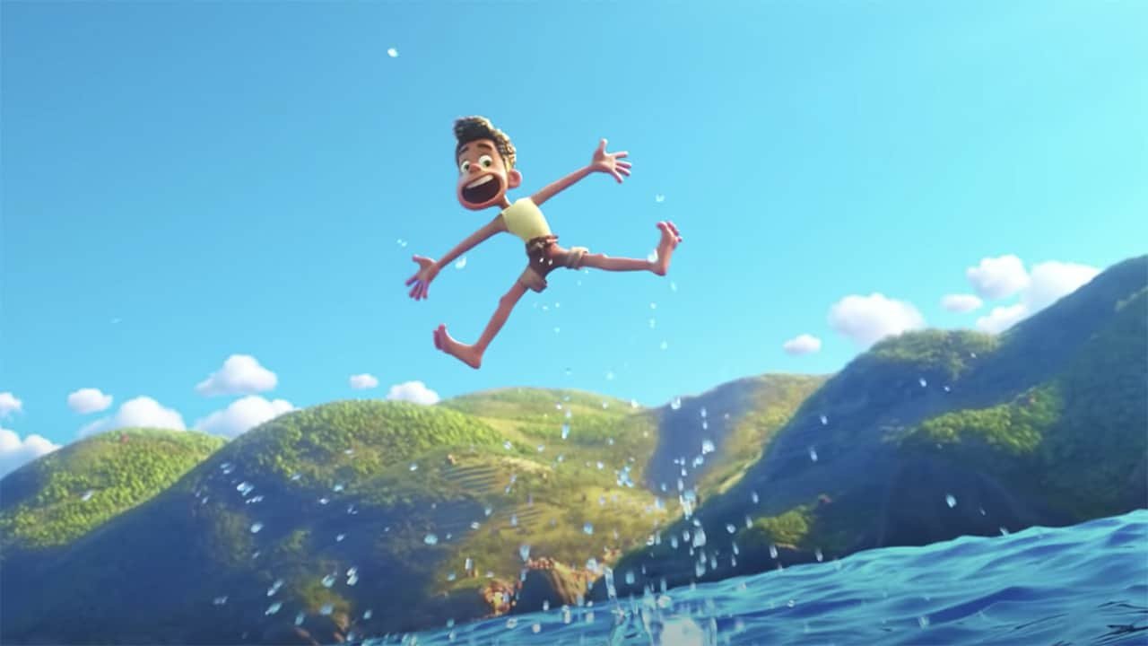 Un jeune garçon joyeux et animé, rappelant les scènes du film « Luca » de Disney Pixar, saute énergiquement au-dessus d'un lac bleu étincelant avec des montagnes verdoyantes et un ciel clair en arrière-plan.