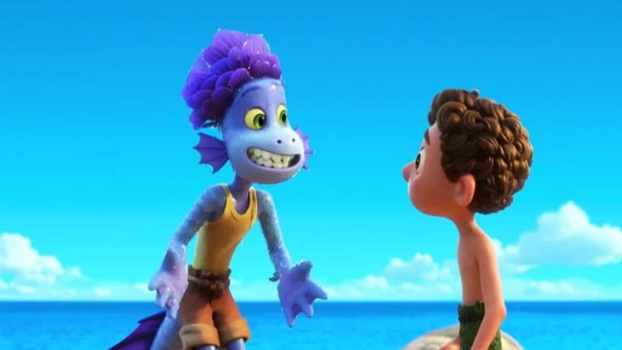Scène animée de "Luca" mettant en vedette un monstre marin violet avec un visage souriant et un garçon aux cheveux violets sur une surface flottante en bois, sur un ciel bleu vif.