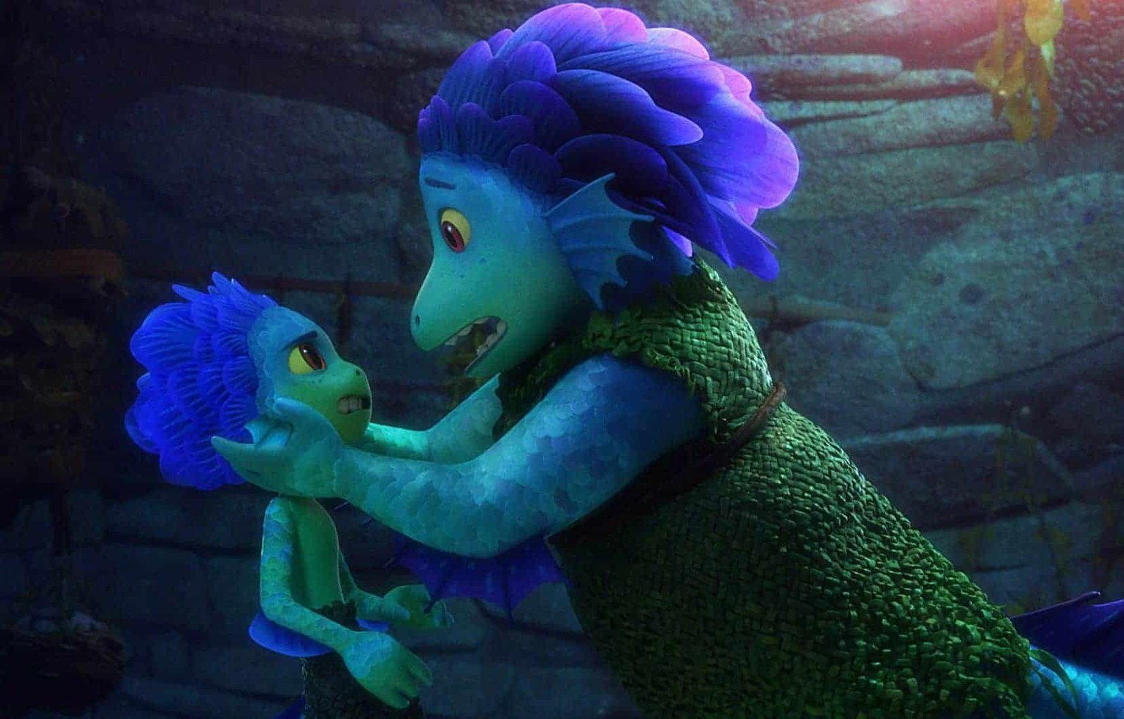 Deux créatures marines animées du film Pixar "Luca" à la peau vert bleuâtre et aux cheveux violets éclatants, ressemblant à de jeunes garçons, partagent un moment d'inquiétude et de connexion sous l'eau, entourées d'un paysage faiblement éclairé.