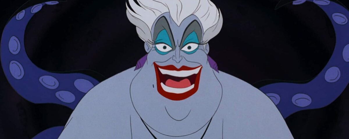 Ursula, l'une des méchantes emblématiques de Disney dans "La Petite Sirène", sourit méchamment avec ses cheveux blancs et ses tentacules violets visibles en arrière-plan.