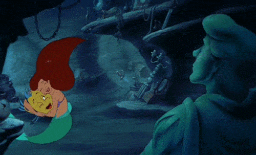 Scène animée de "La Petite Sirène" montrant Ariel assise contemplativement dans son trésor sous-marin, entourée de divers artefacts collectés, avec une expression réfléchie et une lumière rougeoyante autour d'elle, comme des chansons de Disney.