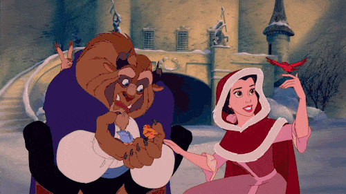 Scène animée de « La Belle et la Bête » montrant Belle dans une cape rouge et la Bête, toutes deux souriantes, partageant un moment ludique dans la cour d'un château enneigé pendant que des chansons Disney jouent en arrière-plan.