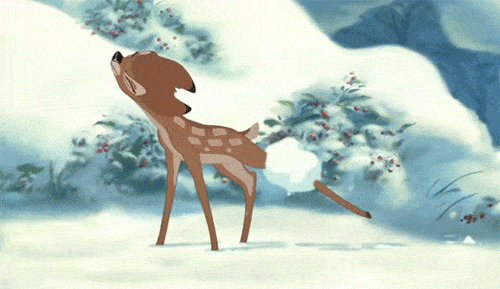 Gif animé de Disney Bambi, un jeune cerf tacheté, se dresse dans un paysage enneigé, entouré d'arbres aux fruits rouges, tandis que des flocons de neige tombent doucement autour de lui.