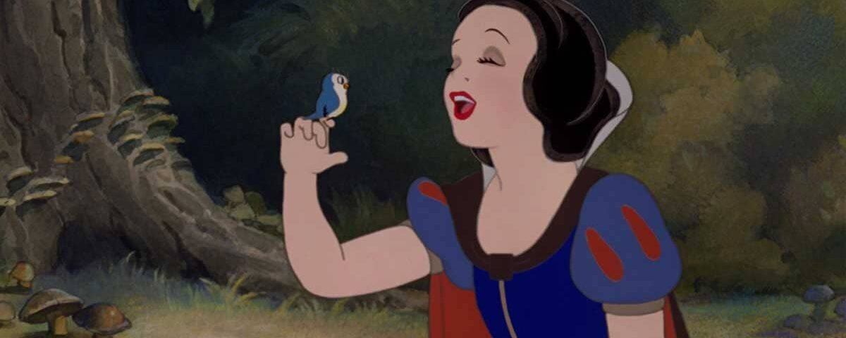 Blanche-Neige, une princesse Disney, sourit et tend son doigt vers un petit oiseau bleu dans un paisible décor forestier.