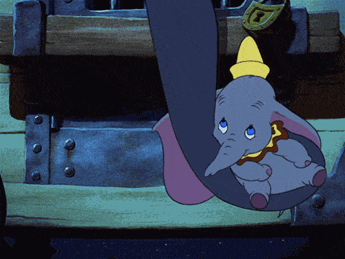 Image animée tirée du film Disney Dumbo, représentant Dumbo, le petit éléphant, portant un chapeau jaune et blotti dans la malle de sa mère alors qu'ils sont tous deux confinés dans une charrette de cirque.