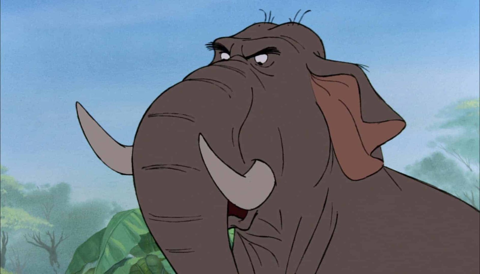 Image animée d'un grand éléphant gris grincheux avec des défenses blanches, des sourcils épais et une expression mécontente, ressemblant à des personnages de Disney, sur fond de jungle brumeuse.