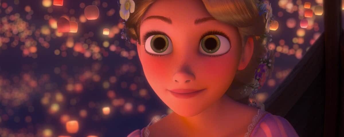 Un personnage animé de Disney aux grands yeux et aux cheveux blonds, vêtu d'une robe violette, regarde avec admiration les nombreuses lanternes flottantes qui brillent sur un ciel sombre.