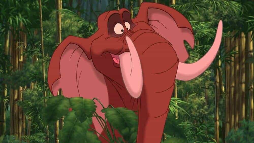 Une image animée d'un joyeux éléphant rouge, rappelant les personnages de Disney, avec de grandes oreilles et de grandes défenses, debout dans une forêt de bambous. L'éléphant apparaît joyeux et vif.