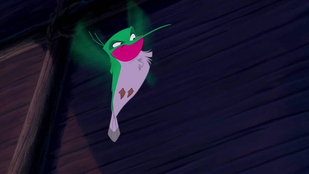 Une image vibrante du personnage animé Ray, une petite luciole verte et rose de « La Princesse et la grenouille » de Disney, brillant d'une lumière verte sur un bois sombre d'inspiration amérindienne.