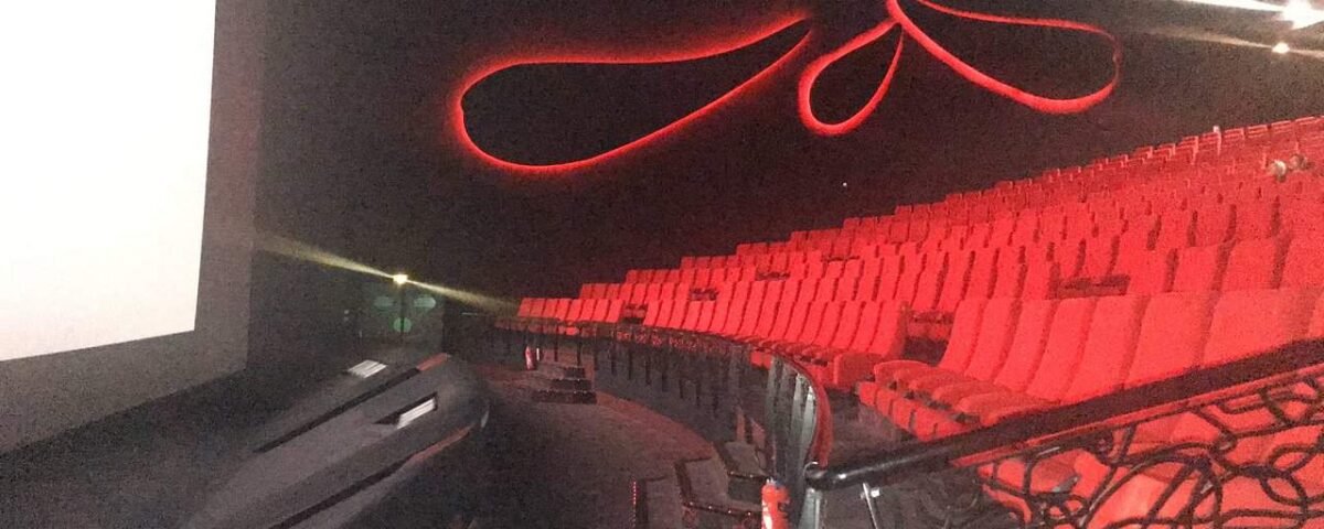 Tarifs. Une salle de cinéma Gaumont avec des sièges rouges et un écran de projection, située à Disneyland Paris.