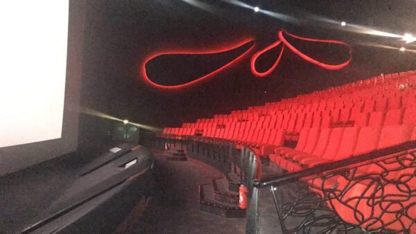 Tarifs. Une salle de cinéma Gaumont avec des sièges rouges et un écran de projection, située à Disneyland Paris.