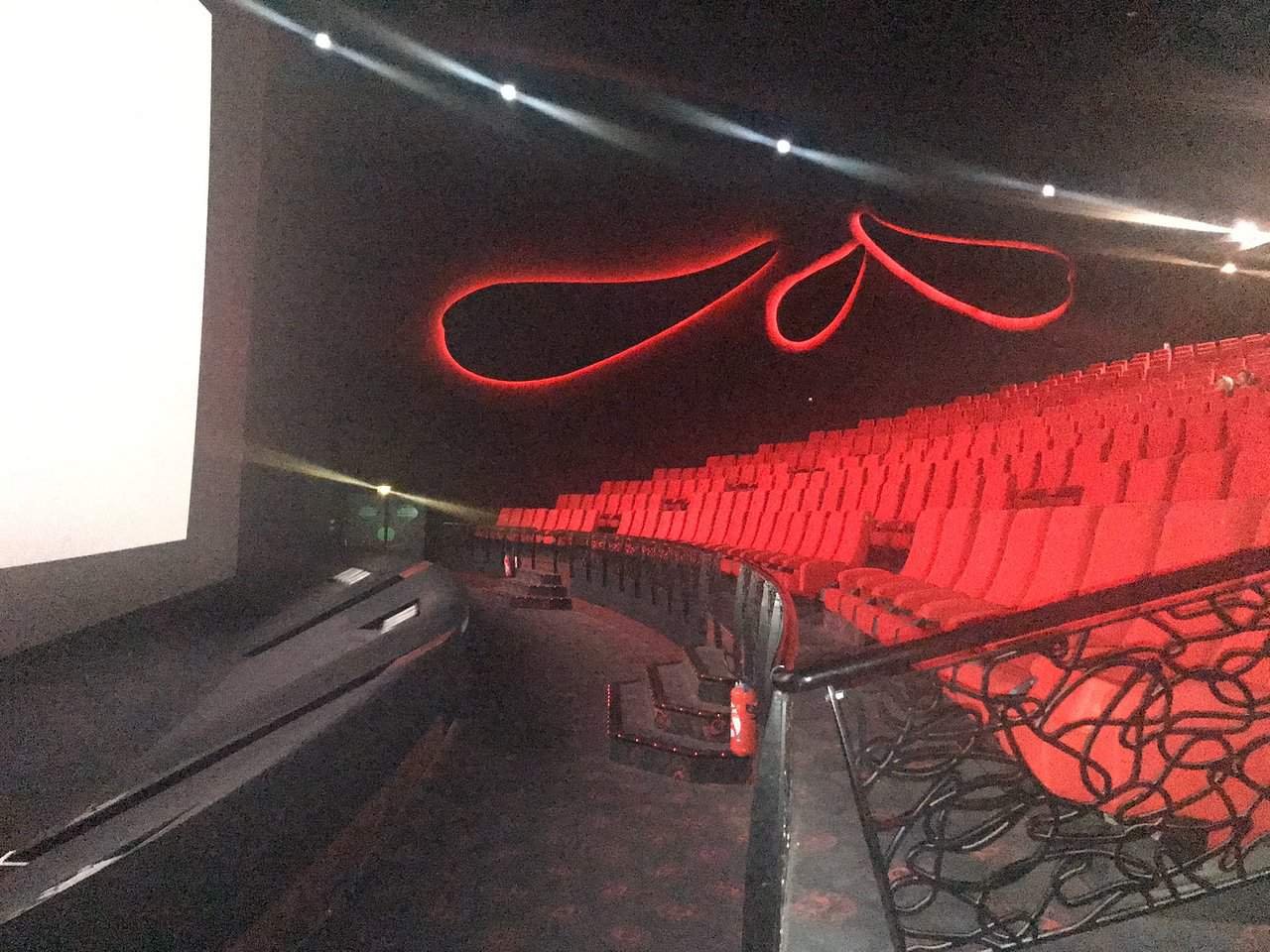 Tarifs. Une salle de cinéma Gaumont avec des sièges rouges et un écran de projection, située à Disneyland Paris.