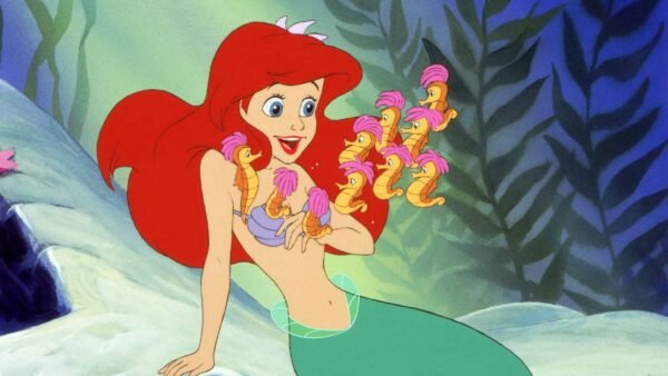 Ariel, une princesse Disney aux cheveux roux, tient joyeusement des objets roses en forme de coquillage tandis qu'un groupe de petits poissons jaunes aux nageoires roses nagent autour d'elle, le tout sur fond sous-marin.