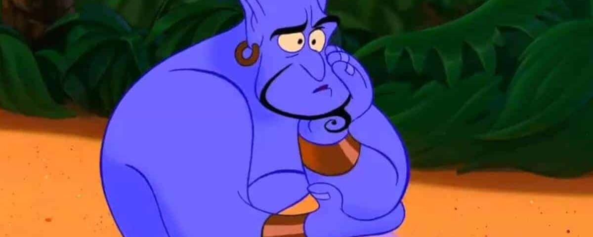 Le génie du film Disney Aladdin avec une expression triste, assis dans une zone sablonneuse avec un feuillage vert luxuriant en arrière-plan. Il a la peau bleue et les poignets jaunes.