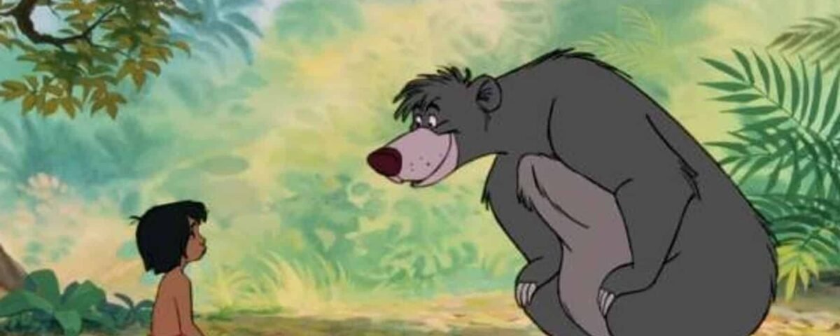 Une scène du "Livre de la Jungle" mettant en scène un jeune garçon assis en face d'un gros ours gris dans un décor de jungle luxuriante. Ils semblent converser ou partager un moment ensemble.