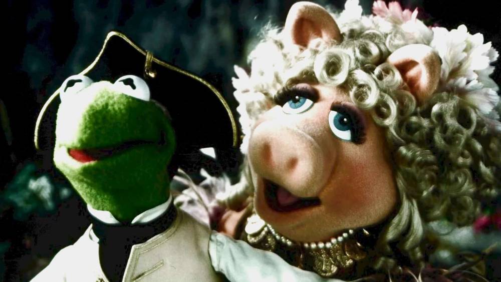 Kermit la grenouille, vêtue d'un chapeau de pirate de "L'Île au Trésor des Muppets", et Miss Piggy, parée de fleurs dans les cheveux, sont représentées