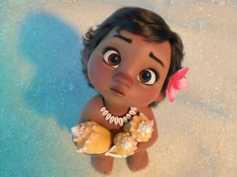 Image animée d'une jeune fille vêtue de vêtements de style Disney, tenant un coquillage, avec une fleur dans les cheveux, regardant vers le haut. L'arrière-plan montre une plage de sable.