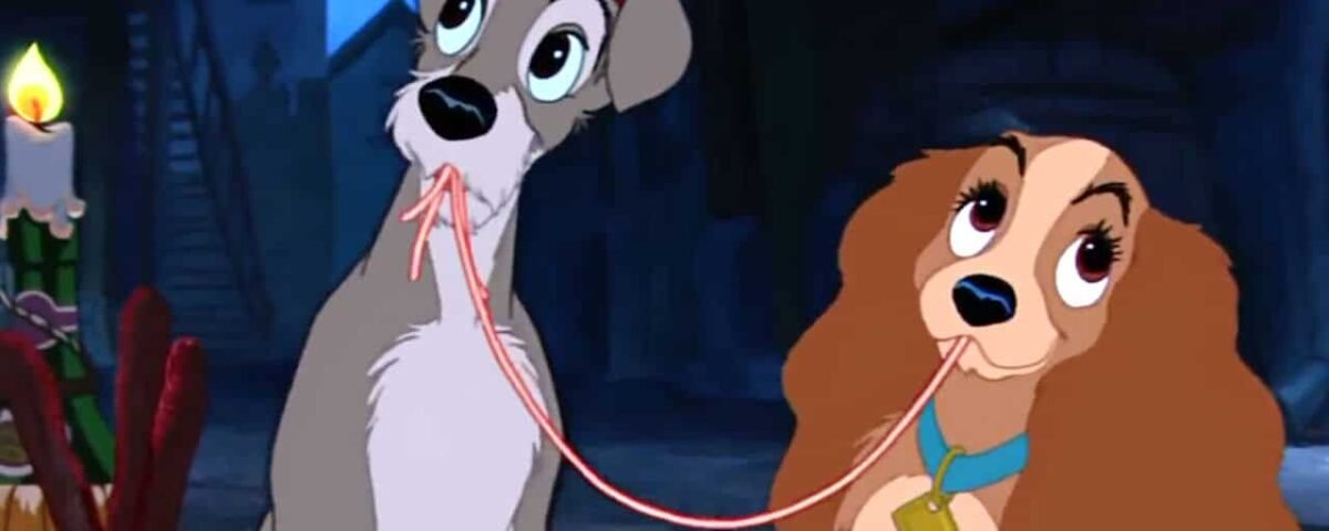 Image animée du film classique "La Belle et le Clochard" montrant Lady et Tramp mangeant des spaghettis, leurs bouches se rencontrant autour d'une nouille partagée, avec un dîner aux chandelles dans le décor