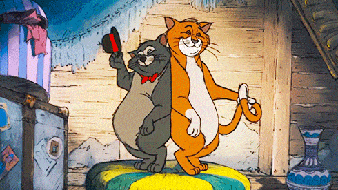 Une image animée de deux chats debout dans une cabane en bois, l'un orange et souriant avec son bras autour de l'autre, un chat gris tenant un poisson lors d'un quiz Disney.