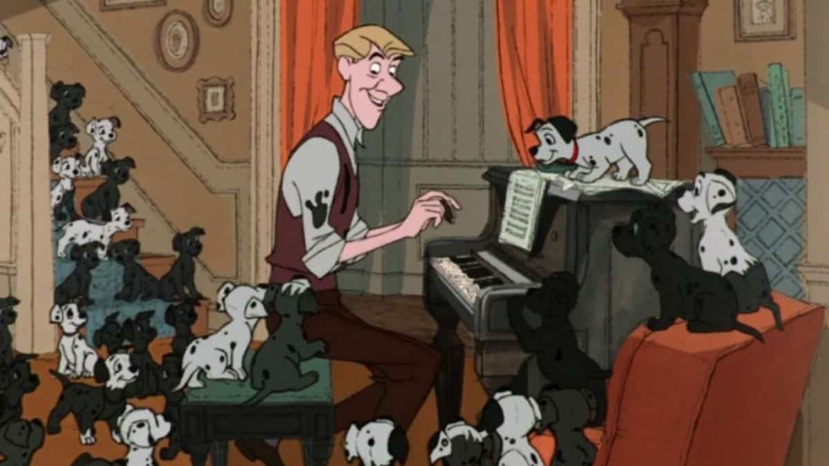 Une image de dessin animé du film "101 Dalmatiens" montrant Roger jouant du piano avec de nombreux chiots autour, dont un au piano interagissant de manière ludique avec lui.