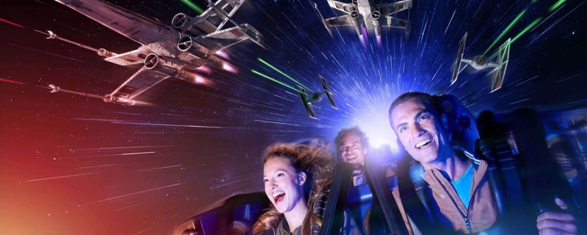 Trois personnes profitant d'une aventure spatiale dynamique en réalité virtuelle à Disneyland Paris, riant et saisissant leurs poignées alors que les vaisseaux spatiaux se battent autour d'eux sur fond d'étoiles et de faisceaux laser colorés.