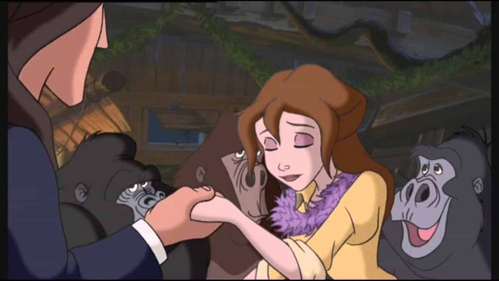 Une scène d'un film d'animation montrant Jane Porter dans une veste jaune et un foulard souriant et tenant la main d'un gorille, avec un autre gorille observant joyeusement en arrière-plan.
