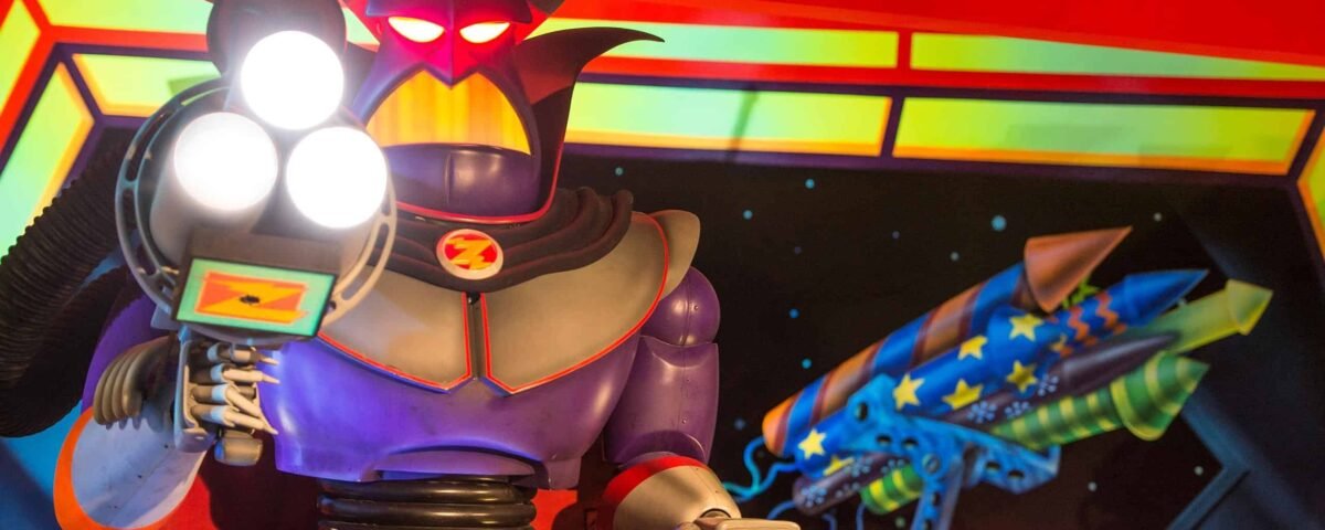 Une figurine robotique colorée au design caricatural, inspirée de Buzz l'Éclair de Toy Story, avec de grands yeux lumineux, un casque diabolique et tenant ce qui semble être un espace