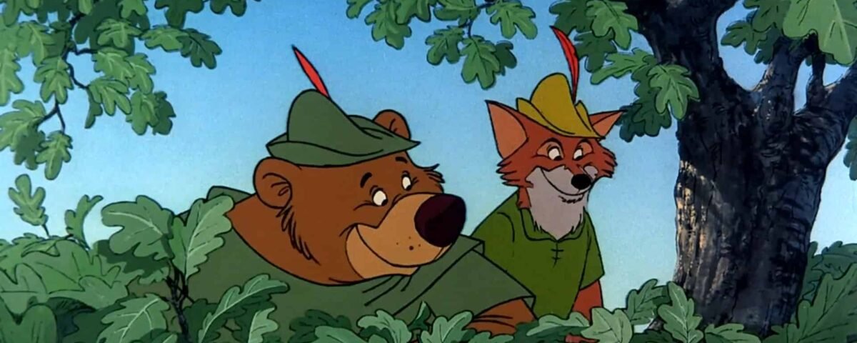 Deux personnages animés, un ours et un renard, coiffés de chapeaux verts rappelant Robin des Bois, regardent derrière un buisson sous un arbre, l'air curieux et alerte.