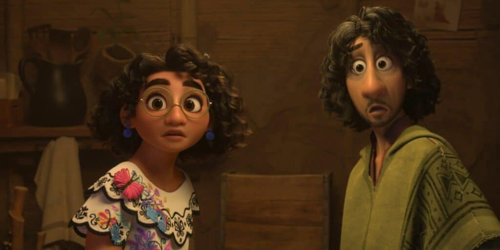 Deux personnages animés dans une pièce chaleureusement éclairée d'un film Disney ; une jeune fille aux cheveux bouclés et aux lunettes, et un homme aux yeux écarquillés et aux cheveux bouclés, vêtu d'une chemise verte, semblent surpris ou