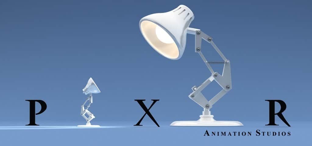 L'image montre le logo des studios d'animation Pixar avec une lampe de bureau stylisée regardant la lettre « i », représentée comme une petite figure personnifiée réalisée à partir de la lettre elle-même.
