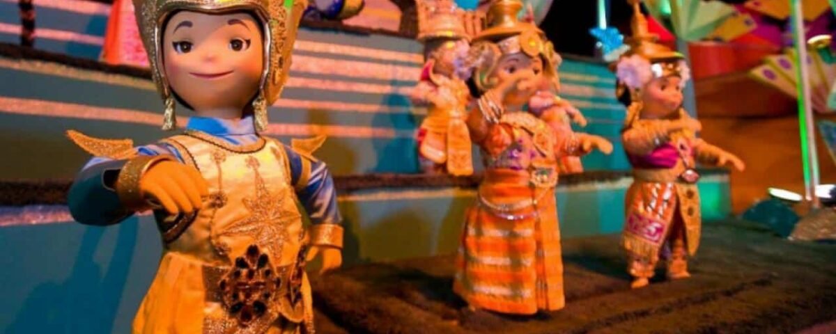 Une exposition colorée de marionnettes animées vêtues de costumes traditionnels asiatiques, avec une marionnette au premier plan pointée vers l'avant, sur un fond vibrant et festif conçu comme un puzzle.