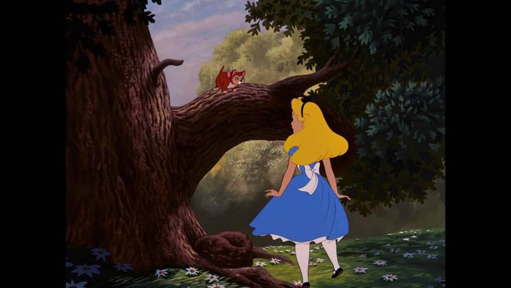 Alice, vêtue d'une robe bleue, se tient à côté d'un grand arbre et regarde une petite créature souriante perchée au creux de l'arbre, dans un décor forestier "Alice au pays des merveilles".