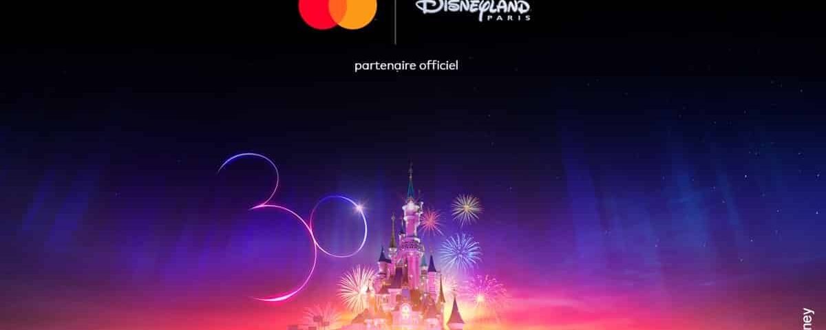Image promotionnelle de Disneyland Paris présentant une scène nocturne lumineuse avec un château magique, des feux d'artifice colorés et "30" écrit dans une écriture lumineuse, célébrant le 30e anniversaire du parc.