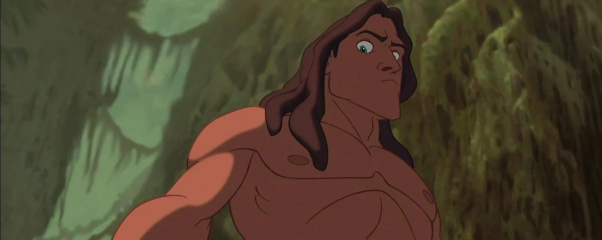 Tarzan, un personnage animé aux longs cheveux bruns coiffés de manière rétro, regarde attentivement devant lui sur un fond de jungle verte et luxuriante. Son expression est pleine d’inquiétude et de vigilance.