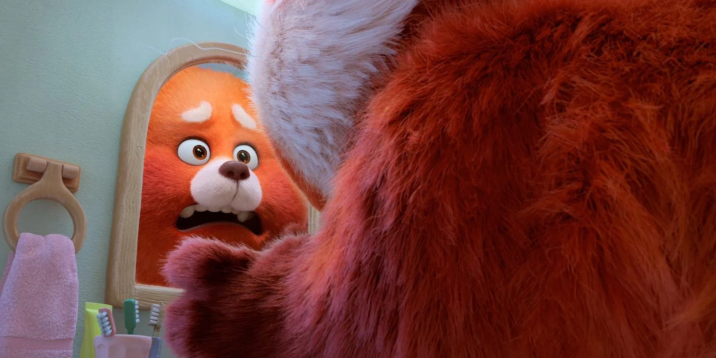 Une créature orange animée avec de grands yeux et une fourrure duveteuse semble rouge vif en voyant son reflet dans un miroir, révélant une créature tout aussi pelucheuse derrière elle.