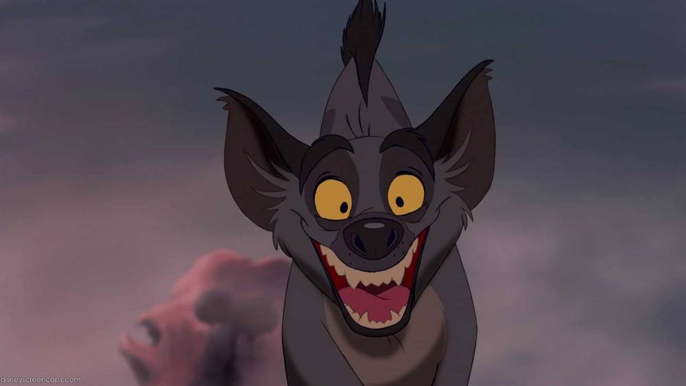 Image animée d'Ed la hyène du Roi Lion, riant avec un large sourire, montrant des dents pointues, sur fond de ciel crépusculaire.